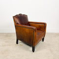 Antique cognac leather club chair with moustache back