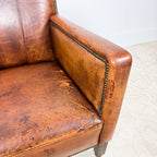 Antique cognac leather club chair with moustache back