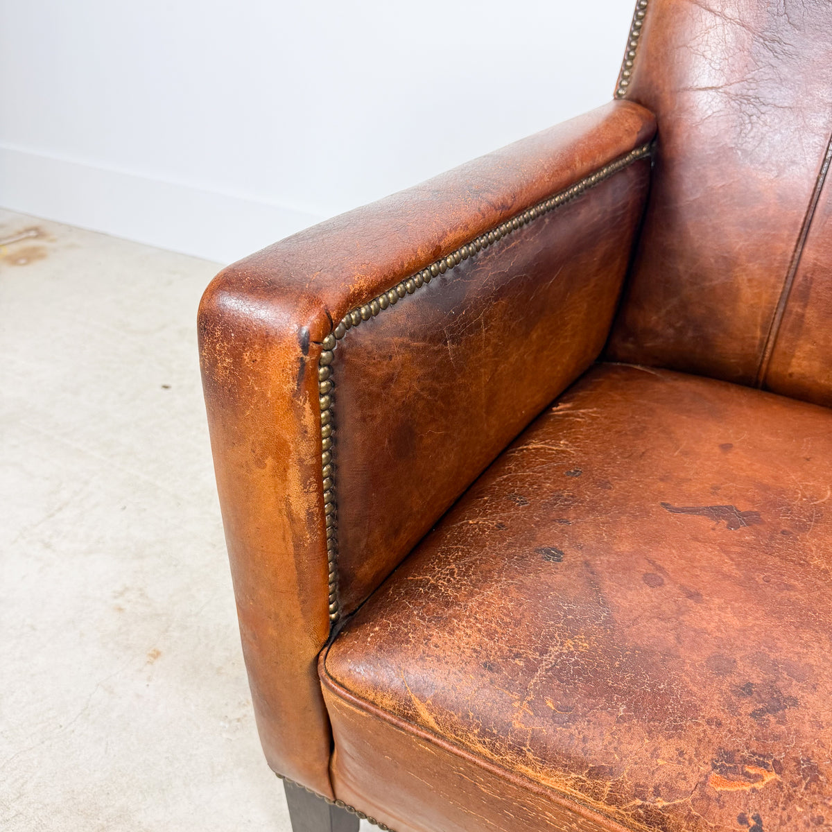 Antique cognac leather club chair with moustache back