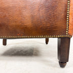 Antique cognac leather club chair with moustache back