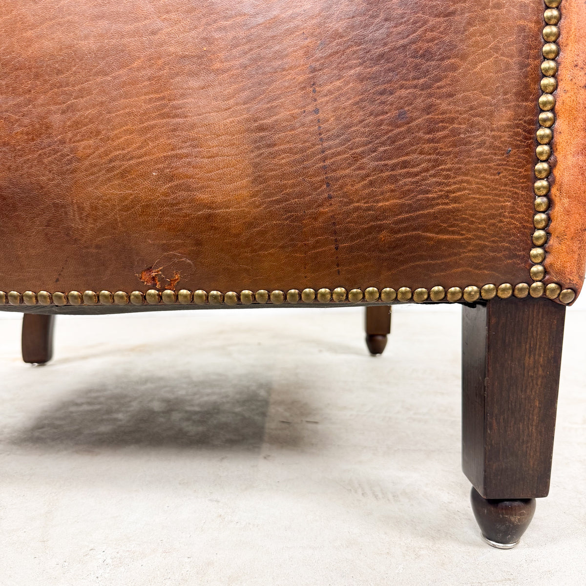 Antique cognac leather club chair with moustache back