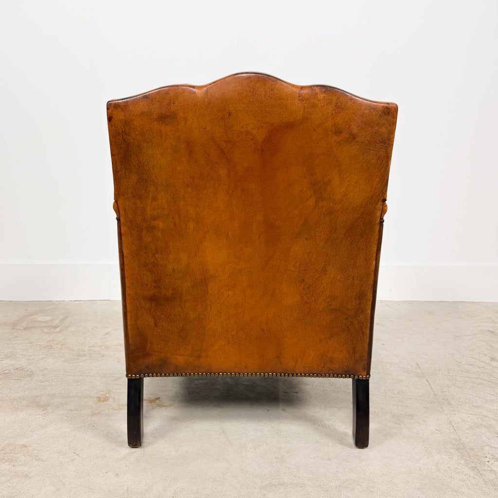 Antique cognac leather club chair with moustache back