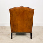Antique cognac leather club chair with moustache back