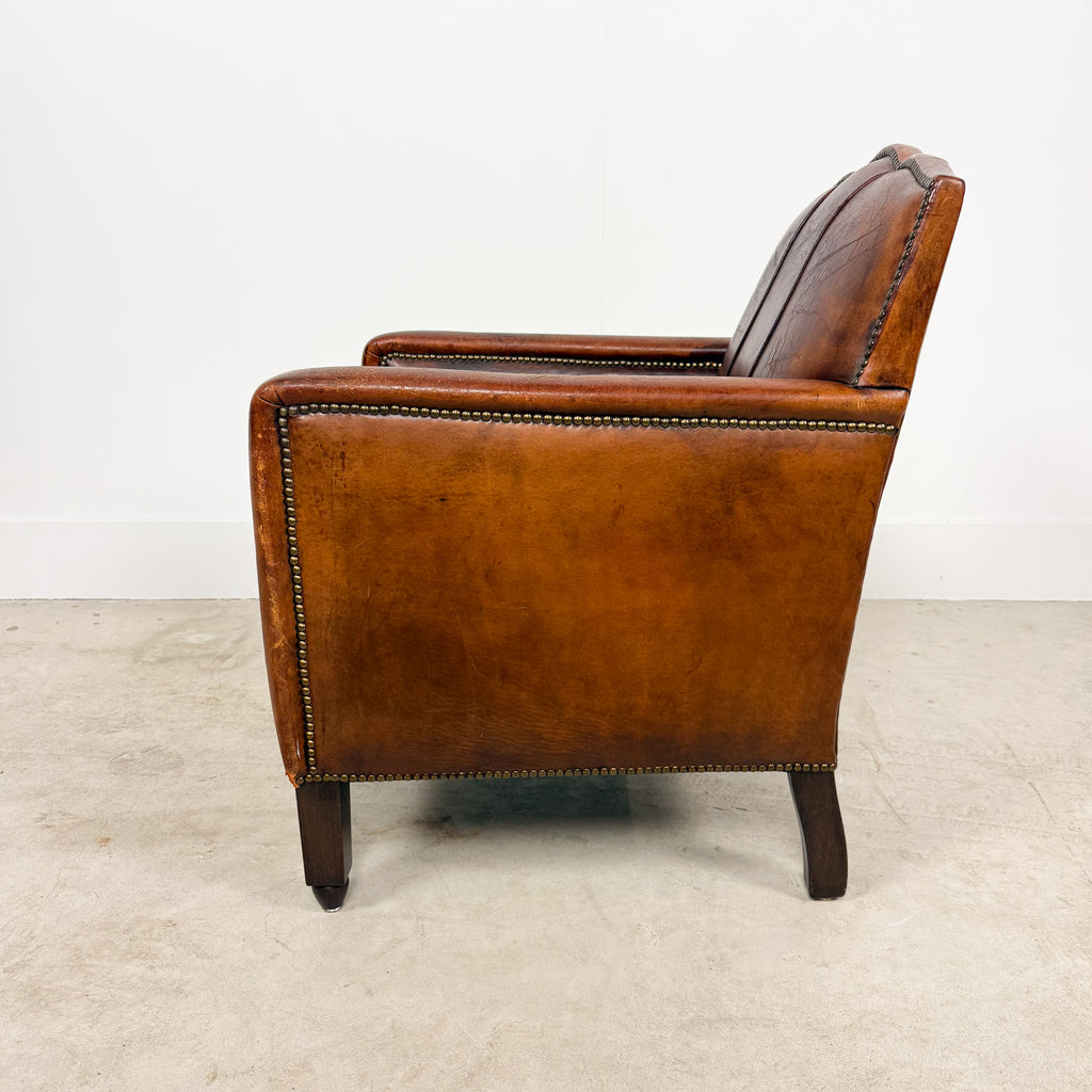 Antique cognac leather club chair with moustache back